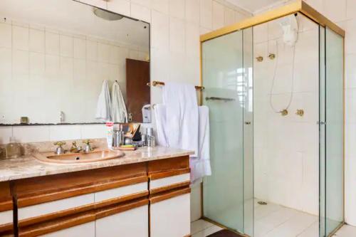 圣保罗Suítes encantadoras的一间带水槽和玻璃淋浴的浴室