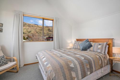 瓦纳卡Wanaka Tranquility - Wanaka Holiday Home的一间卧室设有一张床和一个大窗户