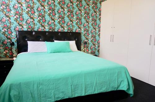 昆斯克利夫奥佐恩塔度假屋的一间卧室配有一张带绿色棉被的床