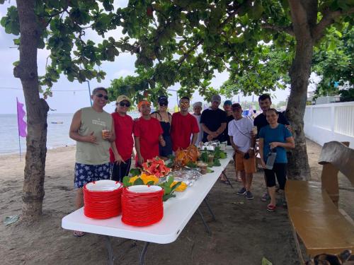 BalibagoBaie Benie Beach Resort的一群人站在海滩上的桌子旁