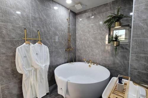 江陵市Dignitas Luxury Villa的一间带大浴缸和水槽的浴室