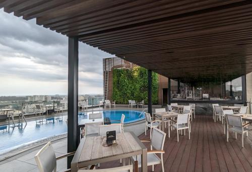 吉大港半岛大港有限公司酒店的一个带桌椅的庭院和一个游泳池