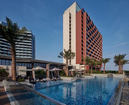 海口海口丽思卡尔顿酒店的一座酒店和一座高楼内的游泳池