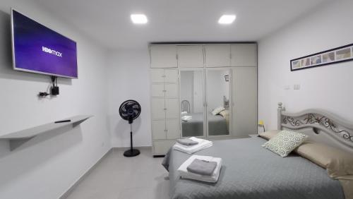 塔里哈Apartamento Privado SOL的白色的房间,设有床铺和墙上的电视