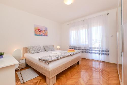 木洛希尼Sea View Apartment Sandra in Mali Lošinj的一间卧室设有一张床和一个大窗户