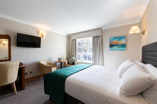 巴利纳巴利纳庄园酒店的配有一张床、一张书桌和一扇窗户的酒店客房