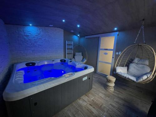 LandisacqLove room le temps d'un plaisir的一个带秋千的房间的大蓝色浴缸
