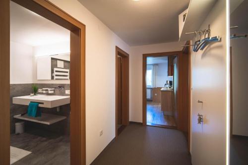 圣加伦基希Alpenherz Apartments的一间带水槽和镜子的浴室