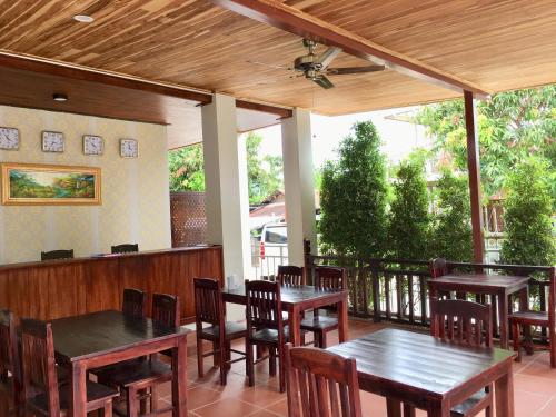 琅勃拉邦Le KhounSok Boutique Hotel的一个带桌椅的庭院和吊扇