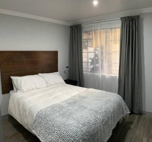 比勒陀利亚Jan Bantjies Inn的一间卧室设有一张大床和一个窗户。