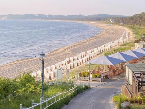 奥斯赛拜-塞林Strandwohnungen Sellin - WG07 mit 2 Balkonen的享有海滩美景,配有遮阳伞和海洋美景。