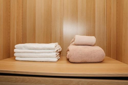 内坦亚Стильные апартаменты Dotan的两堆毛巾放在一个房间里架子上