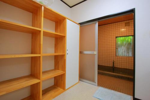 指宿市Family Ryokan Kawakyu with Showa Retro, private hot spring的一间设有木架和玻璃门的房间