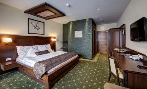 多纳瓦利伽利略多诺瓦利酒店的配有一张床和一张书桌的酒店客房