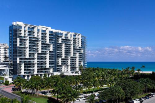 迈阿密海滩南海滩W度假村的一座高大的建筑,在海洋前方种有棕榈树