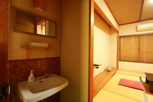 指宿市Family Ryokan Kawakyu with Showa Retro, private hot spring的一间带水槽和镜子的浴室