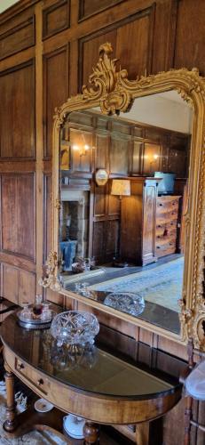 米德尔赫姆Braithwaite Hall Bed & Breakfast的厨房里一面镜子,前面设有一张桌子
