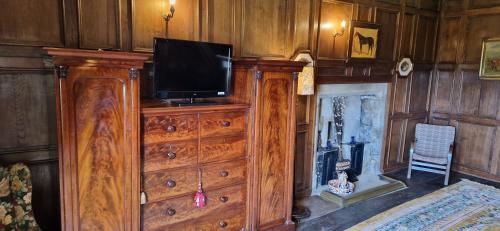 米德尔赫姆Braithwaite Hall Bed & Breakfast的木制梳妆台,上面有电视