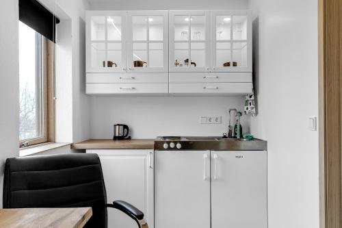 弗吕济Klettar - The Old Hatchery Iceland的厨房配有白色橱柜、水槽和桌子