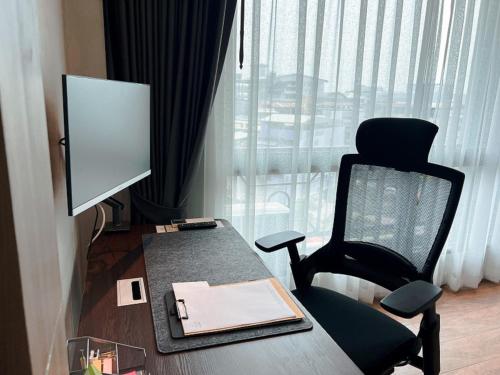 乌隆他尼Civilize Hotel的客房设有书桌、椅子和电脑