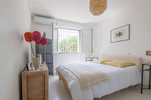 利勒鲁斯U Momentu - appt climatisé avec terrasse的白色的卧室设有床和窗户