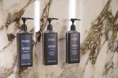 科莫科莫湖喜来登酒店的三个洗发水瓶子坐在大理石柜台上