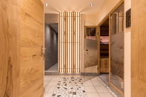 瑟弗浩斯Hotel Castel - pure Lebensfreude的走廊设有木门,铺有瓷砖地板