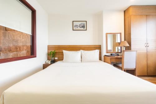 河内一号酒店的卧室配有一张白色大床和一张书桌