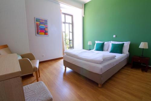 辛特拉WOT Sintra Sarrazola的一间卧室设有一张大床和绿色的墙壁