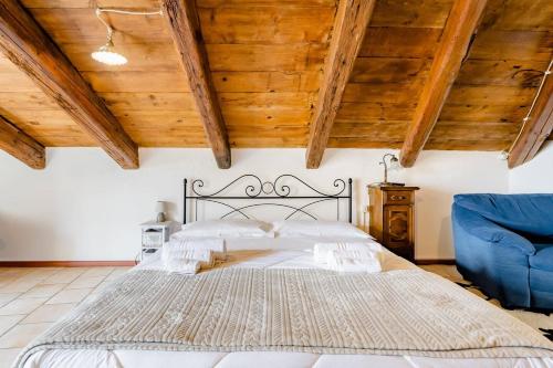 孔韦尔萨诺Mansarda romantica "Il nido delle rondini"的一间卧室配有一张大床和一张蓝色椅子