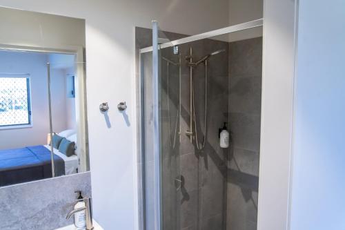 麦凯Mackay Adventure Lodge的带淋浴的浴室和玻璃门