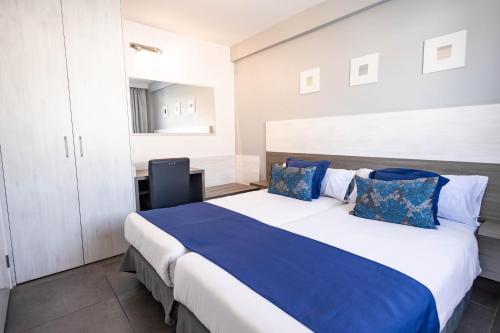 波多黎各Servatur Castillo de Sol的一间卧室配有一张带蓝色枕头的大床