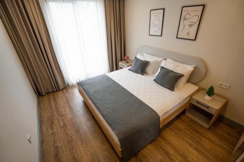 安塔利亚LARA MARİNE HOMES的一间卧室设有一张大床和一个窗户。