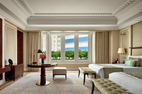 新加坡The Fullerton Hotel Singapore的一间卧室设有一张大床和一个窗户。