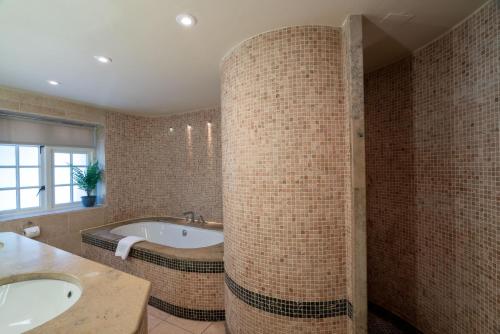 灵伍德High Corner Inn的浴室配有两个盥洗盆和浴缸。