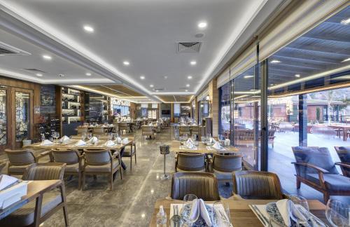 阿拉尼亚Club Porto Amore Hotel Adults Only的餐厅设有木桌、椅子和窗户。