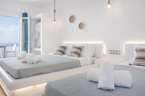 米克诺斯城Feel Breeze的白色卧室配有两张床和一张桌子
