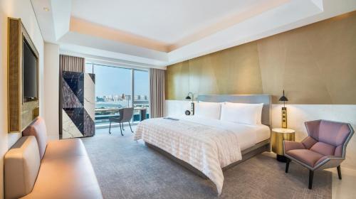 上海上海闵行宝龙艾美酒店的配有一张床和一把椅子的酒店客房