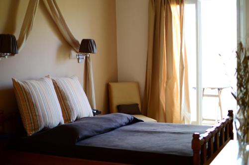 Skala MistegnonPetalidi的一间卧室设有一张床和一个窗户,
