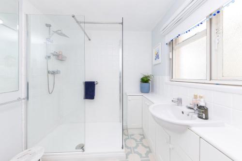 奇切斯特Secluded Spacious Garden Suite的带淋浴和盥洗盆的白色浴室