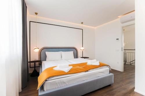 布达佩斯The Amberlyn Suite Hotel的一间卧室配有一张带橙色毯子的大床
