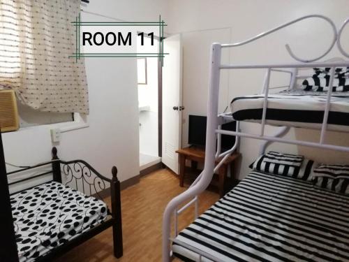 黎牙实比Thirdy's Place Hostel的一间卧室配有一张双层床和客房标志