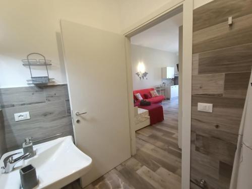 莱韦拉诺Martylè Rooms的一间带水槽和红色沙发的浴室