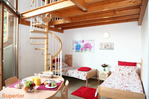 卢加诺卢加诺萨沃萨青年旅舍的一间设有床、桌子和楼梯的房间
