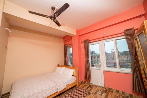 博卡拉Subedi Apartment的一间卧室设有橙色的墙壁和吊扇。