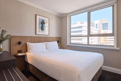 珀斯Pensione Hotel Perth的卧室设有一张白色大床和一扇窗户。