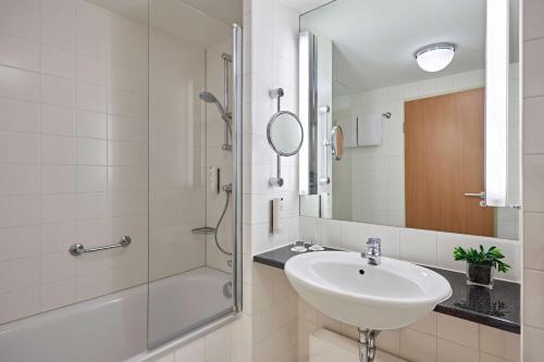 科隆Lindner Hotel Cologne Am Dom, part of JdV by Hyatt的白色的浴室设有水槽和淋浴。