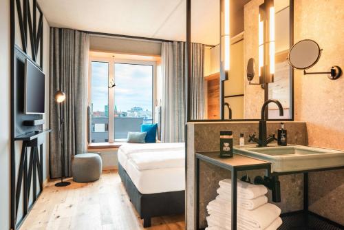 基尔me and all hotel Kiel, part of JdV by Hyatt的酒店客房设有带水槽的浴室和一张床