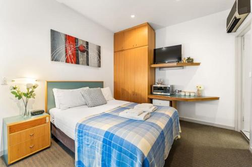 阿德莱德The Hidden Gem - Adelaide CBD的一间卧室配有一张带蓝白色毯子的床