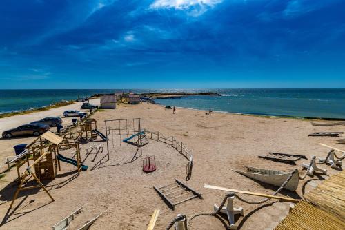 多亚马伊Micul Golf的沙滩上设有游乐场和椅子